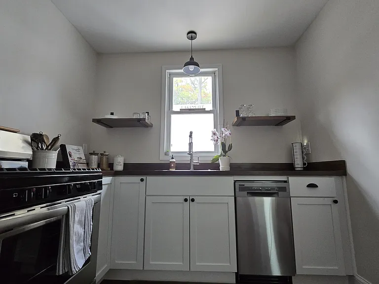 Kitchen with dishwasher, gas stove/range, refrigerator/freezer, microwave, silverware, dishes, hand towels, etc.