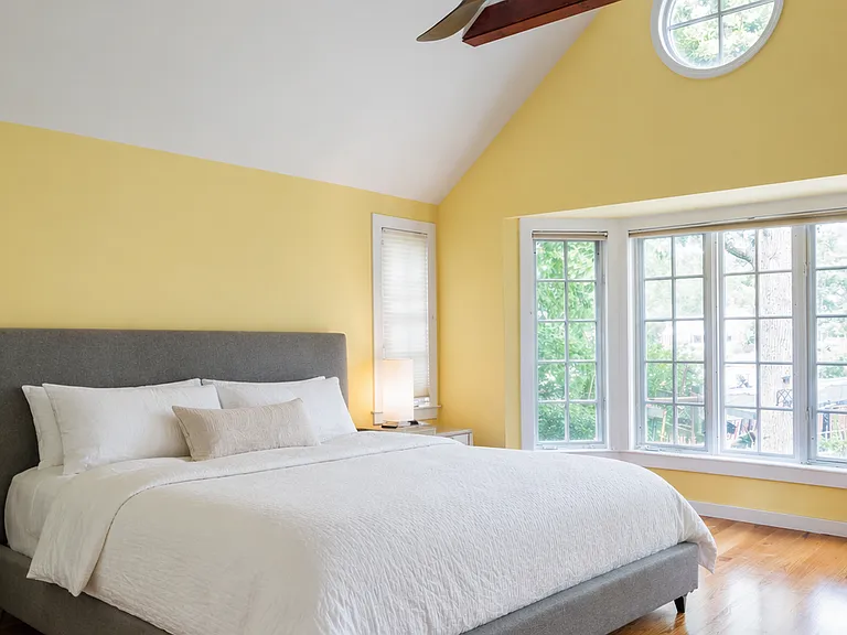 Standout primary bedroom with vaulted cathedral ceilings and large windows.