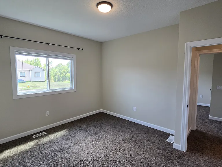 Second bedroom (Third bedroom visible through the doorway) facing the street