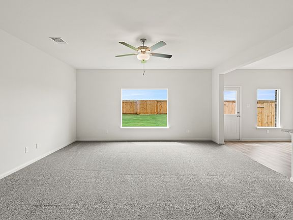 The family room has a large window and plenty of space for furniture.