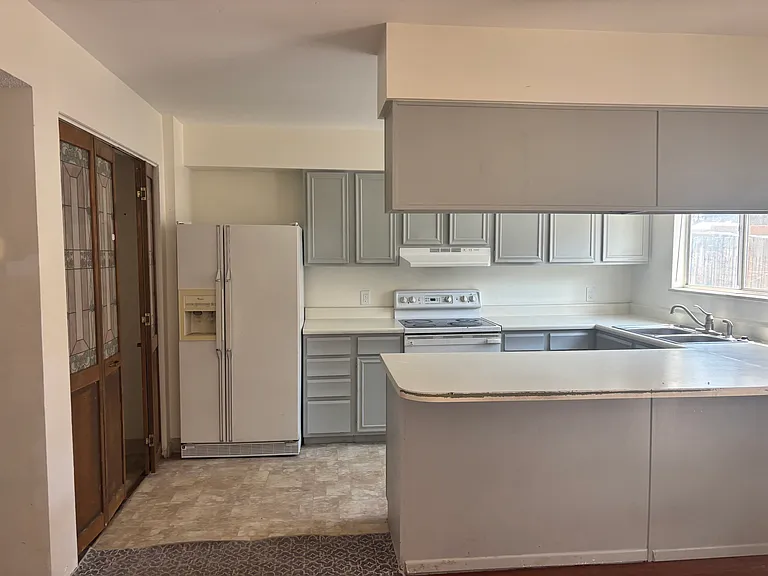Kitchen features new flooring and new refrigerator and stovetop/range
