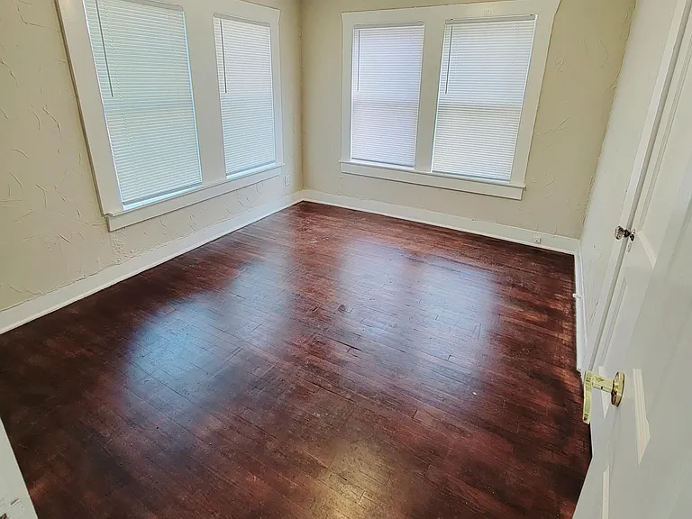 Master Bedroom off of living area, adjacent to bathroom with hardwood floors