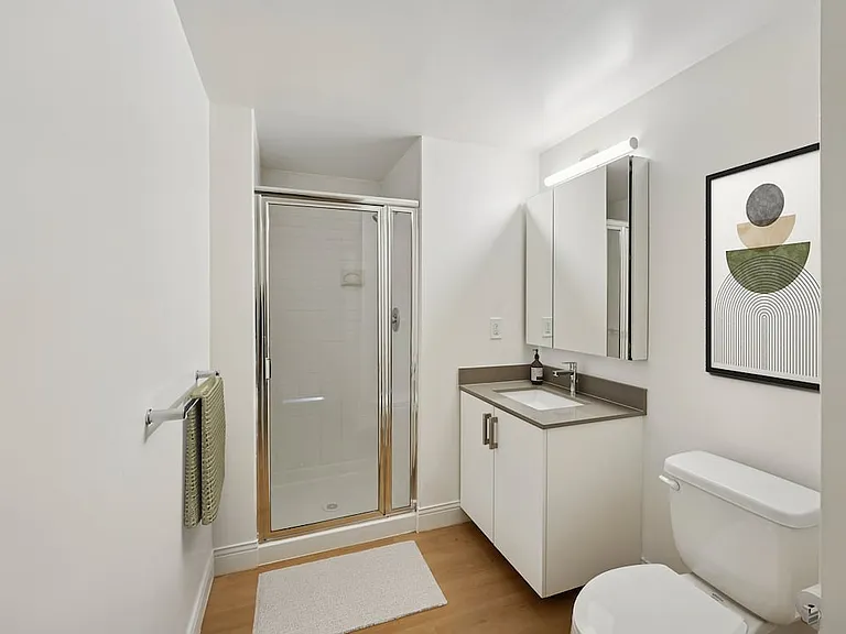 Renovated Package I bath with grey quartz countertop, white cabinetry, and hard-surface flooring