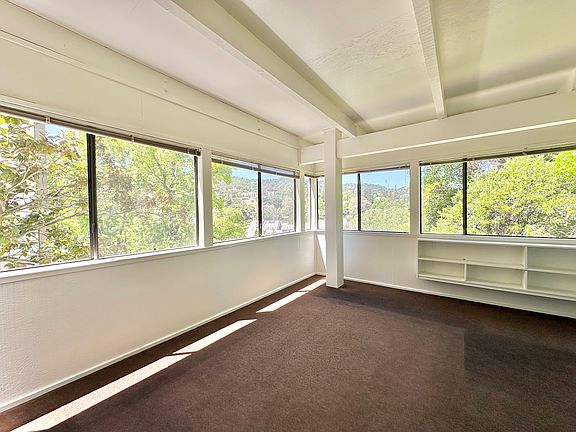 Spacious sunroom with bookshelves.