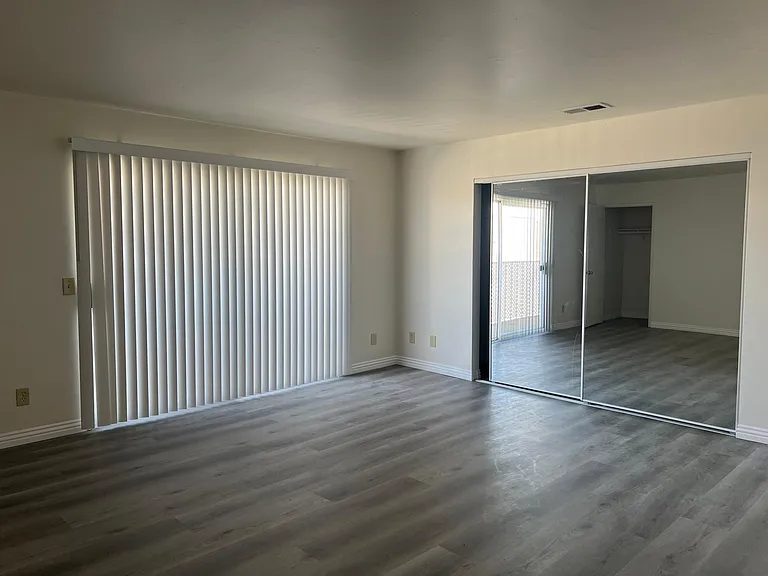 Large master with mirrored closet doors and balcony