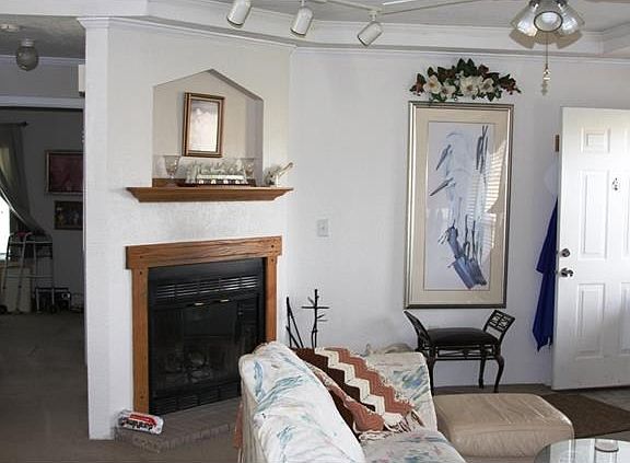 Living room. Wood burning fireplace and entry door on right. M