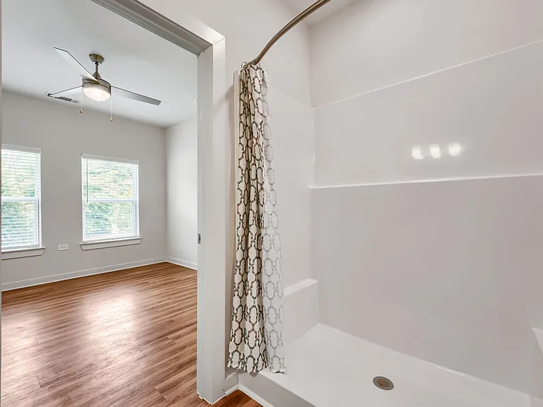 Walk in shower with bedroom in the background