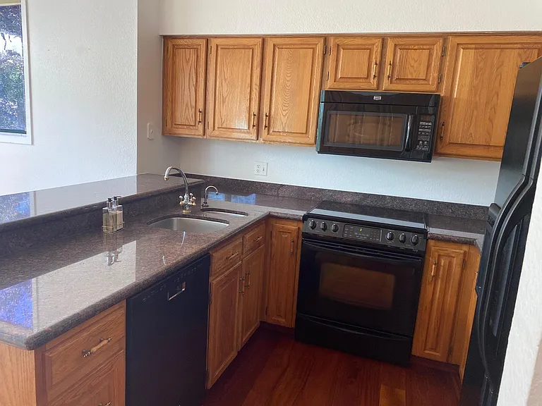 Kitchen with refrigerator, dishwasher, range, microwave.