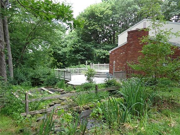Side of house/deck, landscaping, fish pond, perennials.