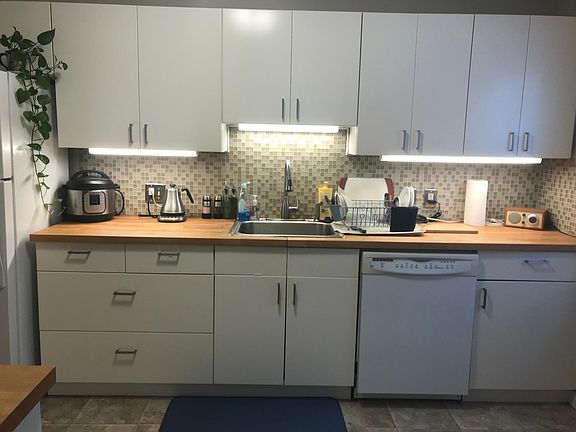 Kitchen features under cabinet lighting and dishwasher.