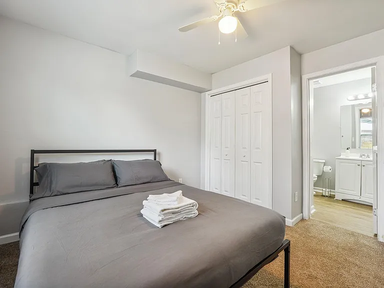 Private bedroom with a ceiling fan, double-door closet, and convenient access to the adjoining bathroom.