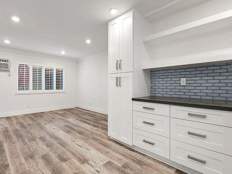 Additional cabinet storage in kitchen with access from living room.