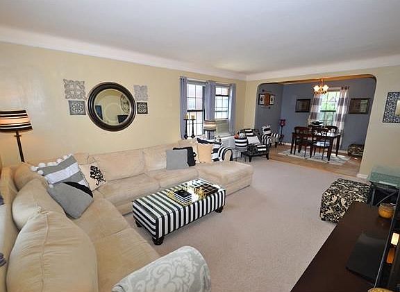 The bright and sunny, corner living room, with Southern and Eastern exposures, has covered hardwood 