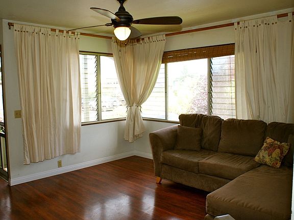 Spacious living room has good air flow through two large windows