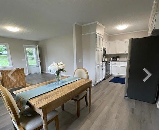 Dining area with view of kitchen, living room, and front door.