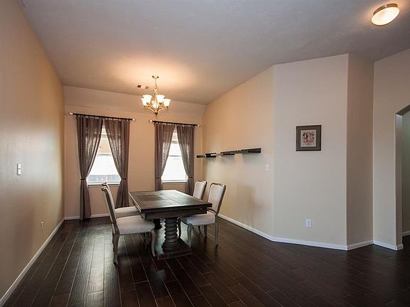 View of dining room with two windows for natural lighting. Porcelain wood tile floors. Plenty of lighting. Nuetral colors.