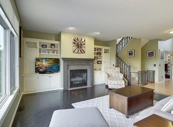 Fireplace is flanked between custom cabinets & is the focal point of the room