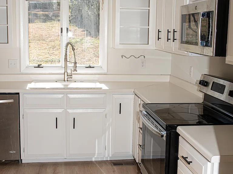 Kitchen with stainless steel appliances. New countertops and a kitchen sink are being installed.