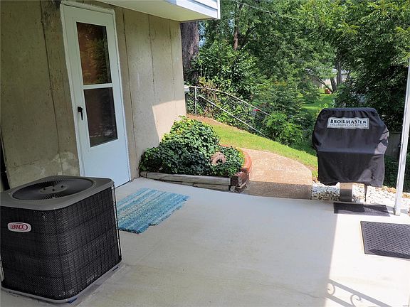 Newer storm door, paved walk-way, gas grill