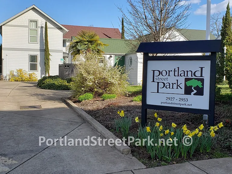 Entrance on Portland St, parking & duplexes in the back