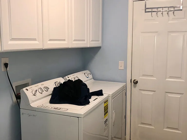Laundry room with cabinet space above & then exterior door to garage exit