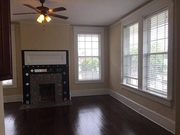 Huge living room, lots of light, with original fireplace