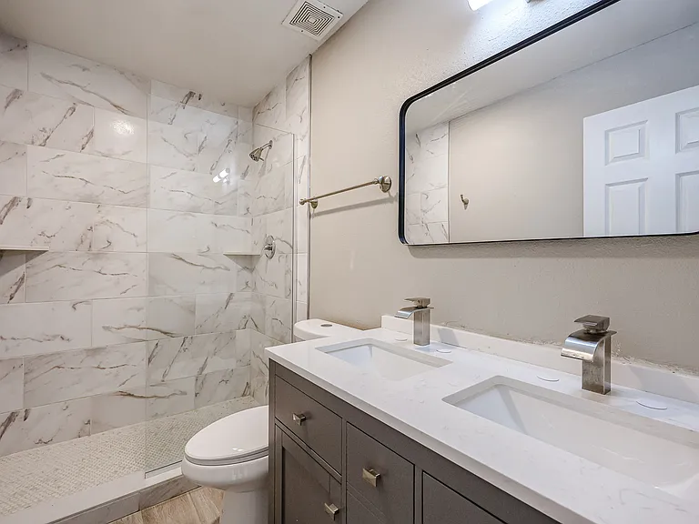 Mater Bathroom. Dual sink with glass walled walk-in shower