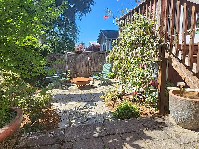 Garden in back of house. Table, chairs, firepit, and BBQ (around side) are included