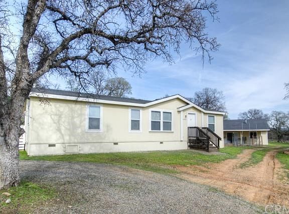 2004 manufactured home with detached studio and 2-car detached garage.