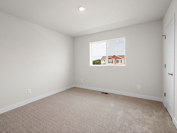 The master bedroom is spacious with a large window.