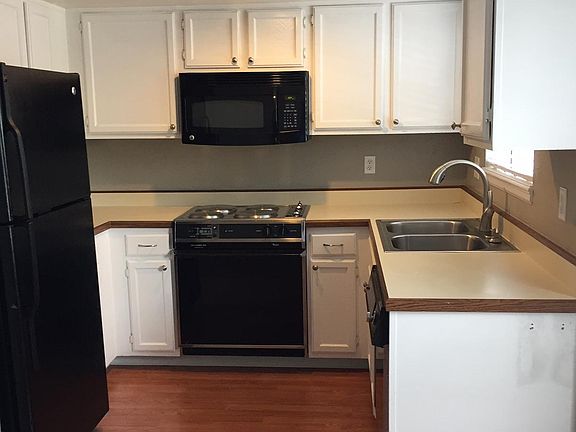 Bright kitchen with stainless, hardwood flooring, and bay window.