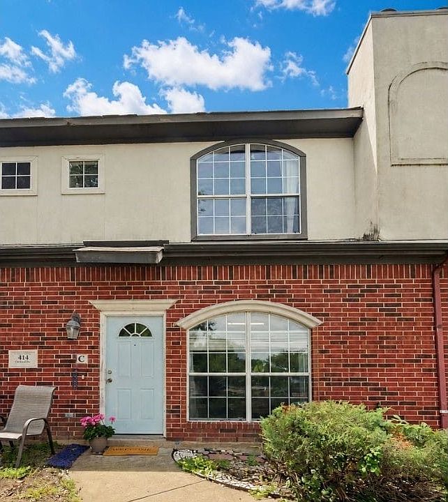The front of the home features brick and stucco, with cast stone door pediment and window arch