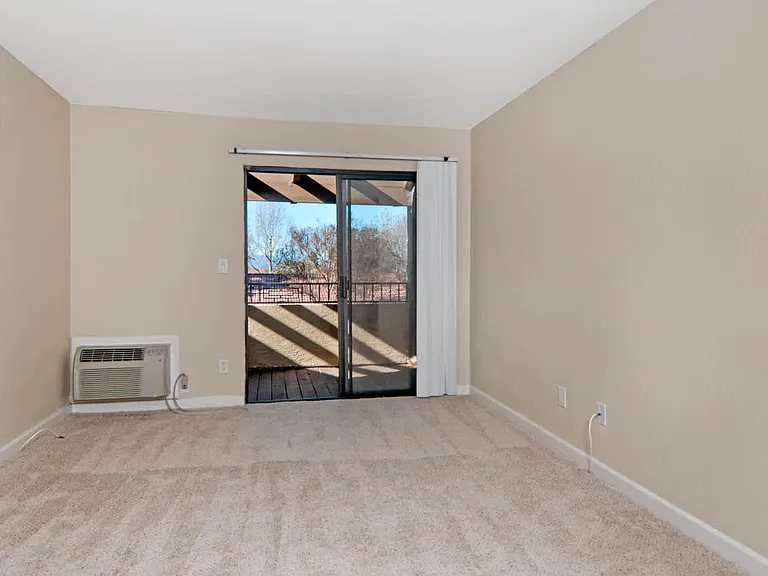 Carpeted Living Room with Balcony