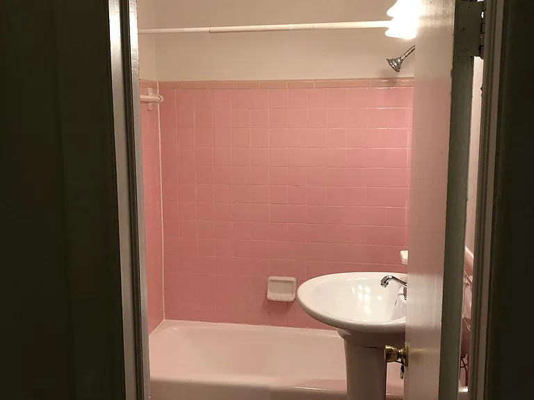 View of bathroom tub/shower and sink from hallway.