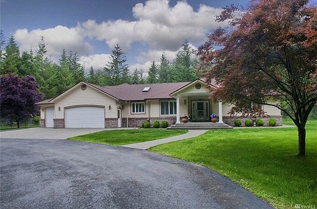 U-shaped driveway with a large concrete slab leading to a 3-Car garage and an inviting covered entrance to the home.