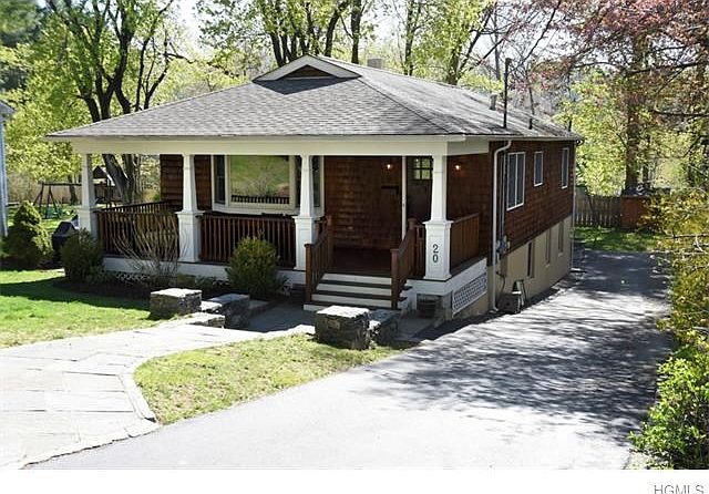 Tranquil setting for this front porch Craftsman-style home with full walk-out lower level