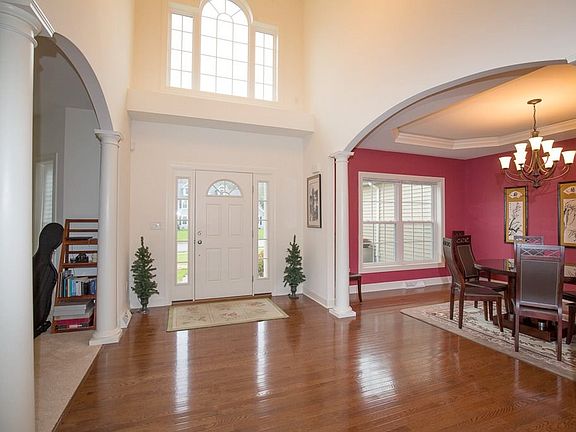 Sun-filled foyer and arched doorways to dining room and living room.