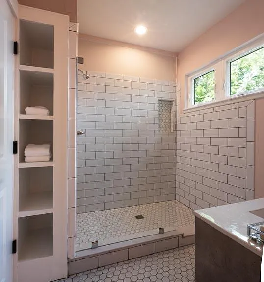 Spacious and bright tiled shower with built in storage