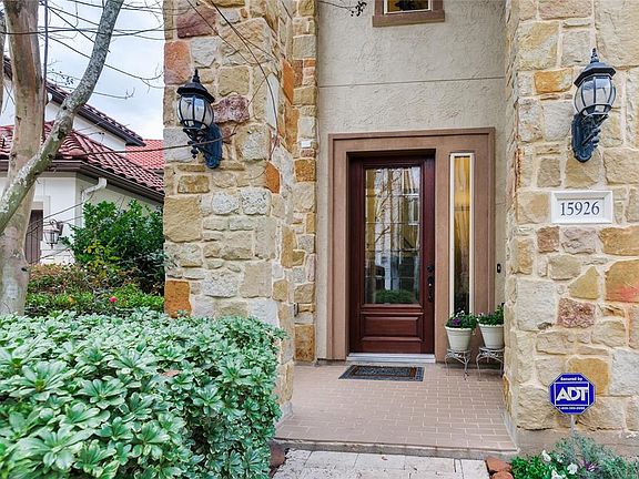 Freshly Stained Front Cedar Door looks like New! the Glass Insets allow the Natural Light and the Attractive Landscaping welcome you as you drive into the Pavered Drive Way.