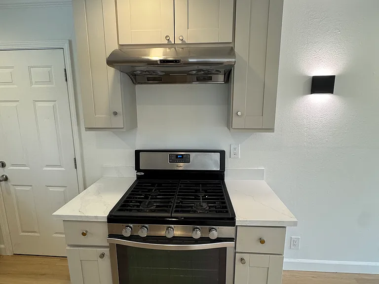 New kitchen range and hood. The left door accesses the storage room, laundry