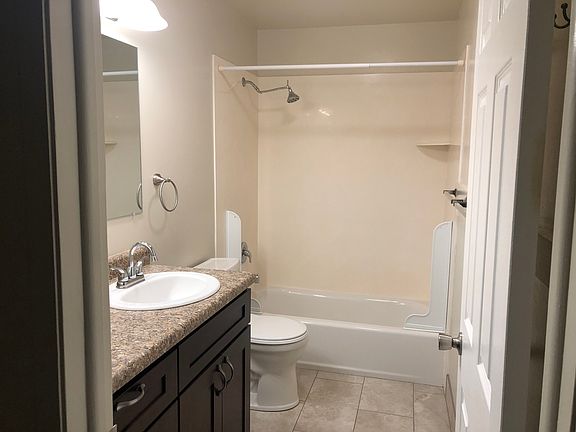 bathroom with large mirror, towel racks, robe hooks and exhaust fan.