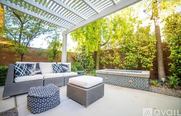 Private outdoor space with fire pit and gas barbecue grill and lounging deck surrounded by mature plants