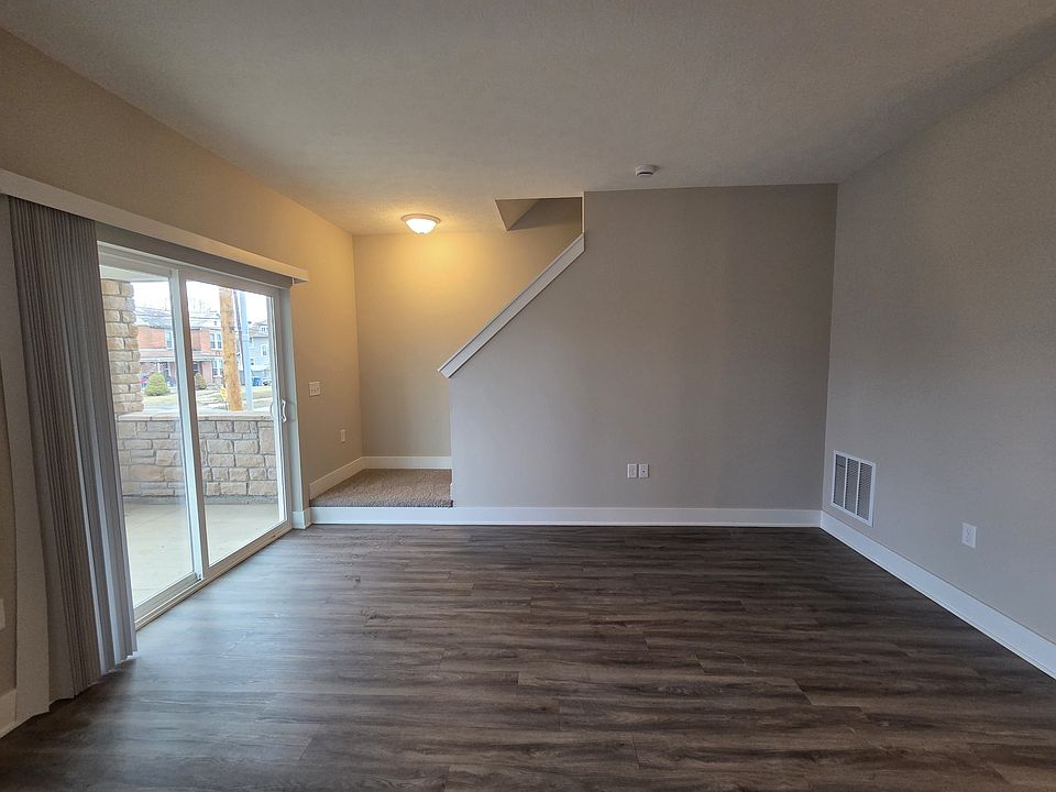 Townhome living area with walkout patio and stairs leading to second level.