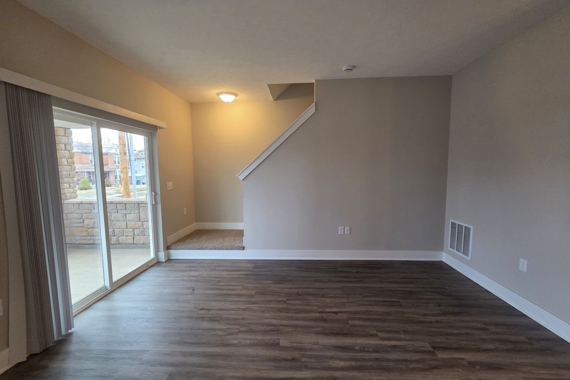 Townhome living area with walkout patio and stairs leading to second level.