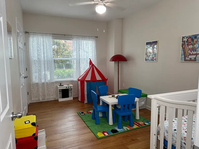 Bright and cheerful children's room with colorful play area, mini kitchen set, and vibrant circus tent. Bright and cheerful children's room with colorful play area, mini kitchen set, and vibrant circus tent.