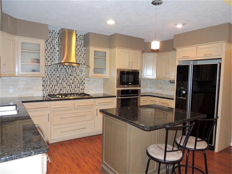 Beautifully updated kitchen with granite countertops and stone backsplash