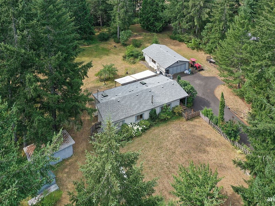 Drone view of home, garage and outbuilding. Note long driveway, separate longer than normal detached garage, and fenced-in large yard. >