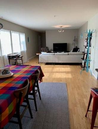 Spacious and open living/dining/kitchen area. View from dining table towards living room with 48 inch flat screen TV