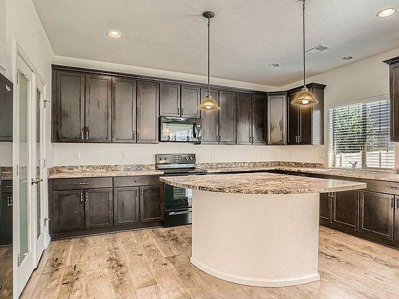 Large kitchen with tons of cabinets, ample counter space, large island & pantry.