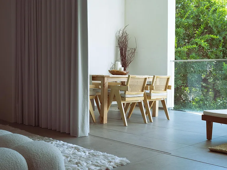 Indoor-Outdoor Dining with Lush Greenery _ Dine in style with floor-to-ceiling glass doors that open to a private terrace, offering a seamless blend of nature and contemporary elegance.